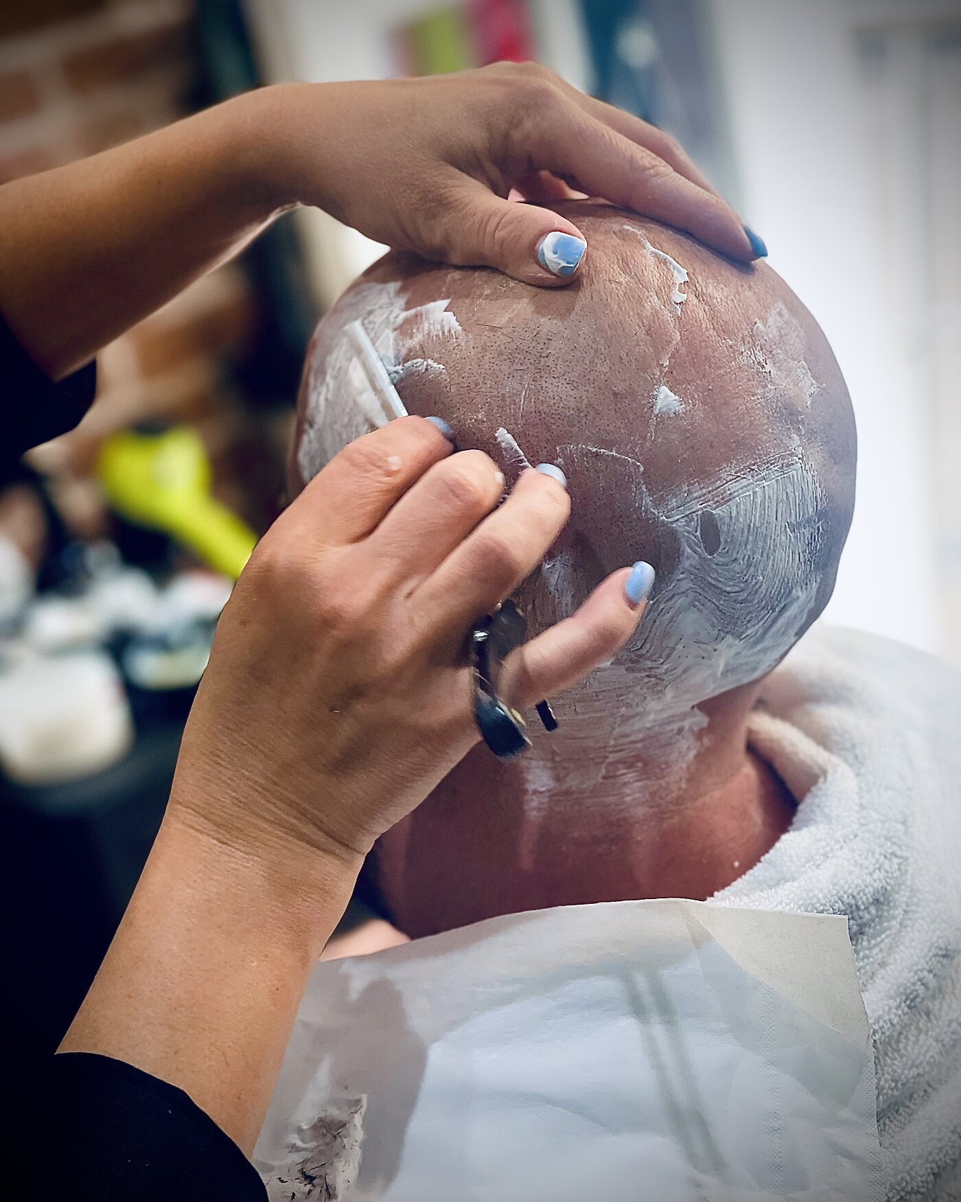 Barber applying a traditional hot towel shave treatment