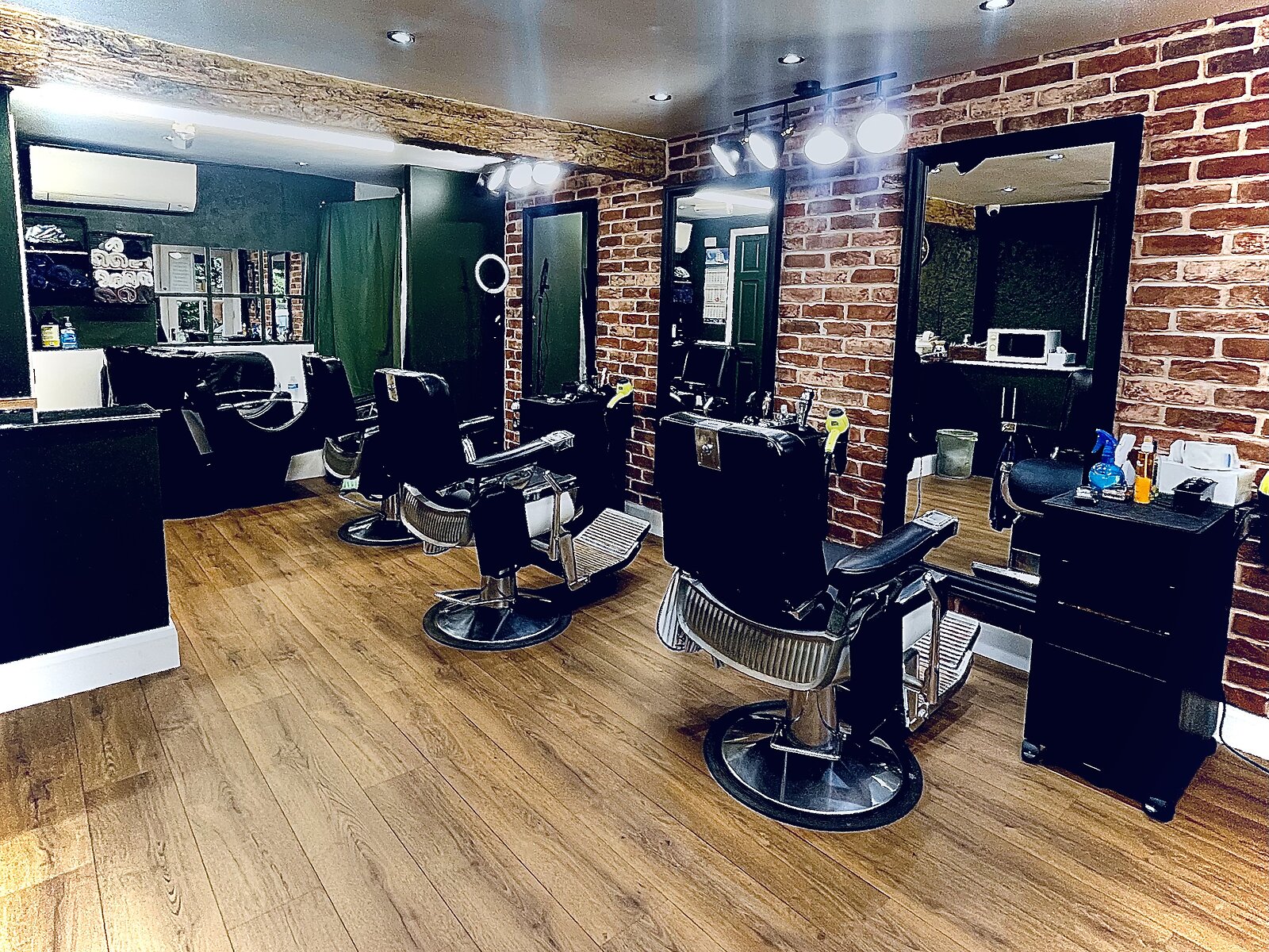 Wide view of the Hairport barber shop interior with exposed brick walls