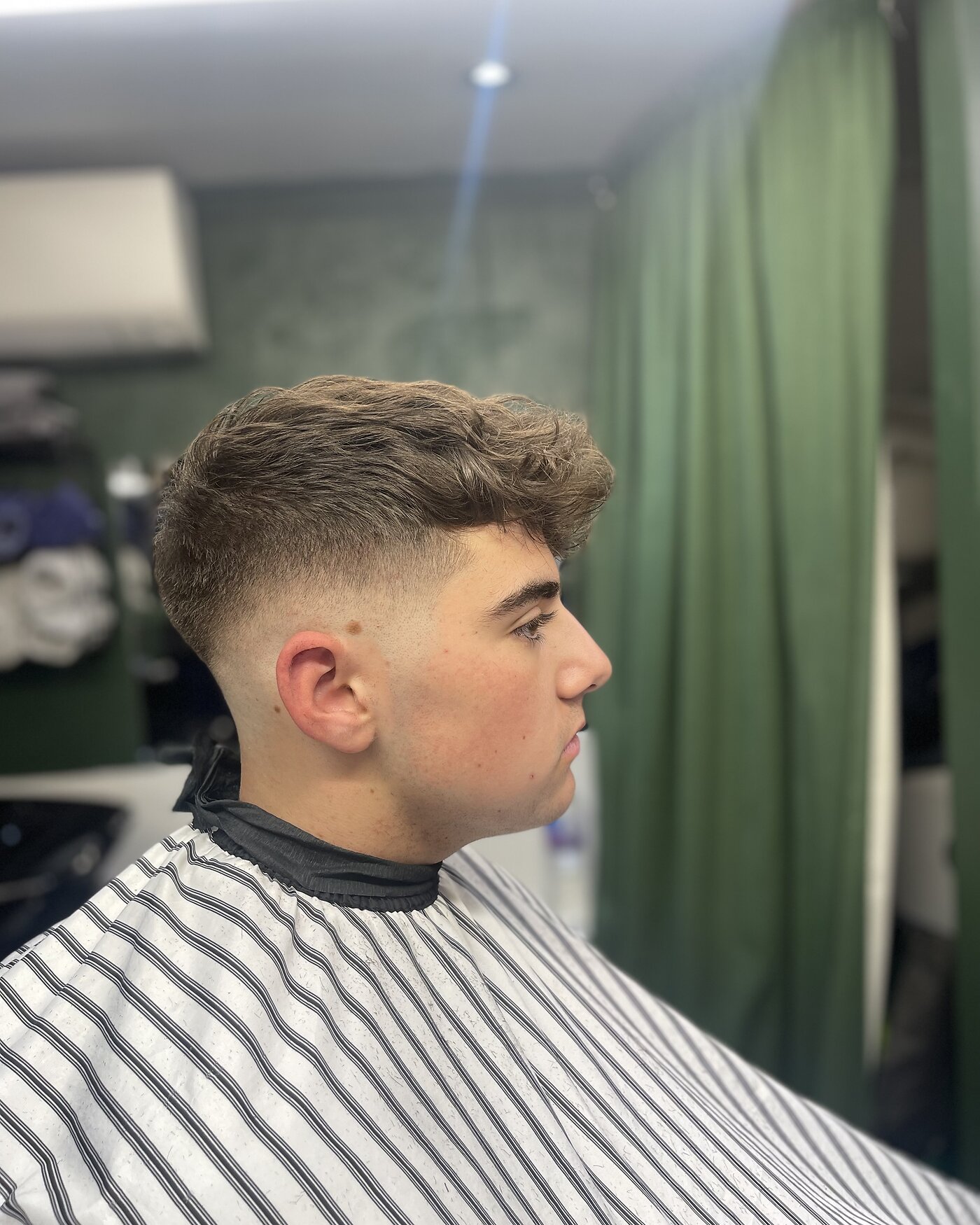 Close-up of a finished skin fade haircut with textured top